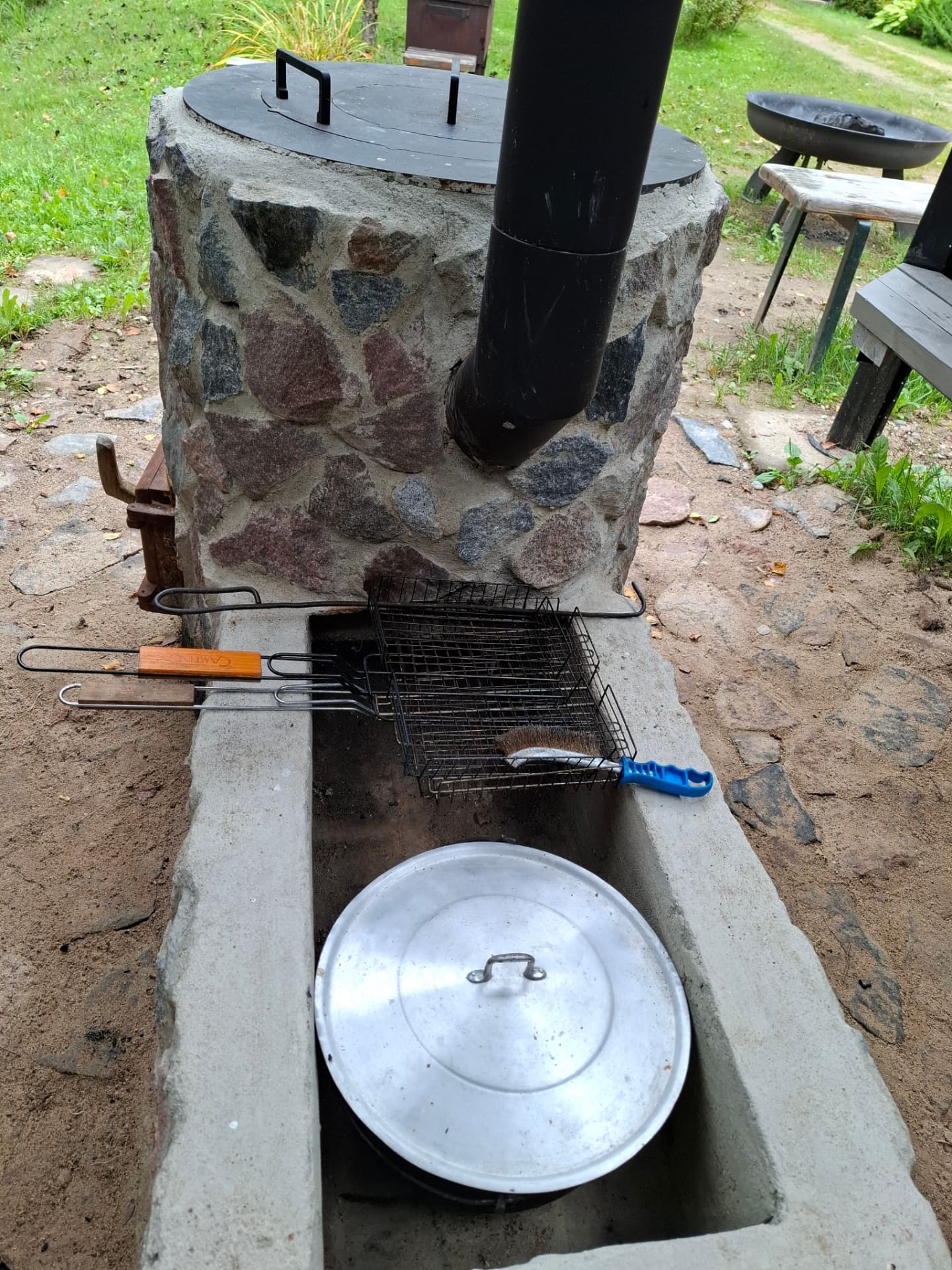 Akmens grils ar restēm un katlu Lēveru pagalmā